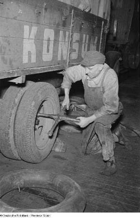 Kraftfahrzeugschlosser bei der Montage von LKW-Reifen