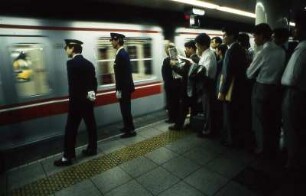 Tokio. Metrofahrer. Passagiere warten am Morgen im Berufsverkehr diszipliniert auf die nächste Metro