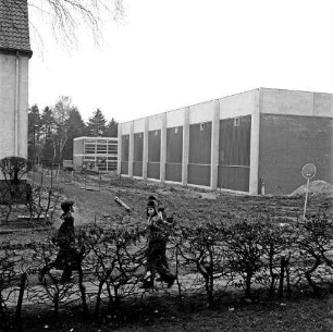 Sporteinrichtungen: Sporthalle: Emil-von-Behring-Gymnasium: Sieker Landstraße: Außenansicht vor Einweihung: vorn Hecke: dahinter zwei Schüler: dahinter unbefestigtes Außengelände: hinten links Schulgebäude