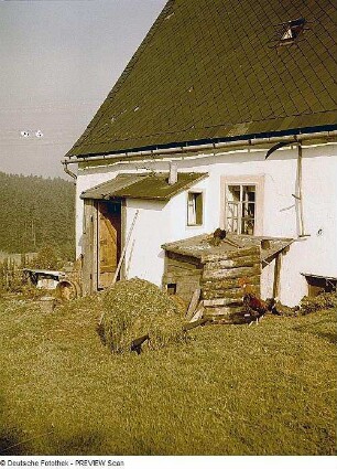 Zinnwald-Georgenfeld. Georgenfelder Bauernhaus, Feldseite mit Mistkarre vor Windfang
