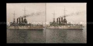 Kriegsschiff mit Beibooten vor Anker