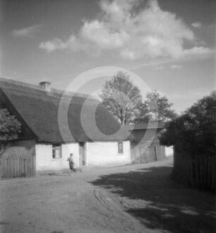 Dorfstraße mit Bauernhaus in Polen