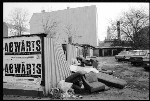 Plakat der Band "Abwärts" an einem Garagenhof mit Sperrmüll