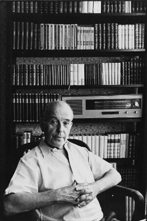 Der Schriftsteller Wieland Herzfelde in seiner Wohnung vor einem Bücherregal