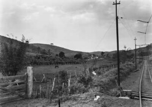 Landschaft in Brasilien : Blick in eine brasilianische Landschaft. Rechts verlaufen Gleise, links eine Koppel mit einem Pferd, dahinter Hügel.