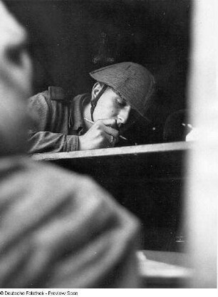 Deutschland . Truppenübungsplatz Klietz. Nationale Volksarmee - Landstreitkräfte. Soldat mit Stahlhelm an einem Arbeitsbrett, vermutlich Aktualisieren einer Lagekarte
