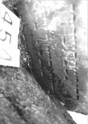 Grabstein 454 (Index: 99898194) Material: Sandstein Zustand: teilweise angewittert, eingesunken Maße HxBxT: 80x57x9 cm Beschreibung: Stele mit Konvexbogenabschluss, Stein steht nahe an einem Baumm und ist etwas eingesunken Besonderheit: Kindergrab: Grabstein 454 (Detailaufnahme)
