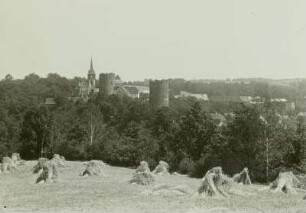 Kohren, Blick auf die Stadt über ein abgeerntetes Feld mit Kornpuppen