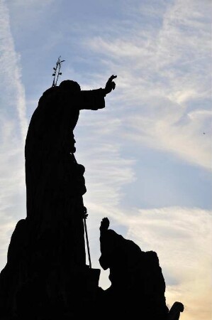 Heiligenfigur : Einer der Steinheiligen auf der Prager Karlsbrücke im abendlichen Gegenlicht aufgenommen