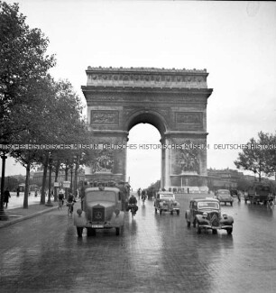 LKW mit deutschen Soldaten fährt die Avenue des Champs-Élysées runter, im Hintergrund der Arc de Triomphe