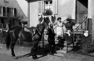 Freiburg; St. Georgen: St. Georgsritt; Reiter neben Pferd an Hausaufgang