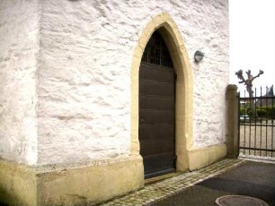 Kirchturm Basis mit spitzbogig gewändeter Tür im Westen