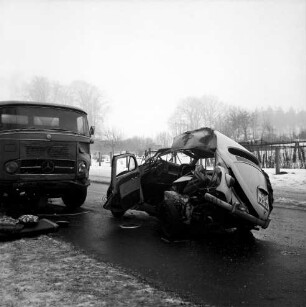 Unfall: Jersbeker Straße: Kollision von VW-Käfer mit Getränke-Lkw: links Trage: im Hintergrund Zaun, Straßenbäume und Bauerngehöft: Winter