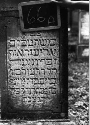 Grabstein 66 (Index: 100090766) Material: Sandstein Zustand: stark verwitt. m. Textverl/Giebel beschäd. Maße HxBxT: 156x59x24 cm Beschreibung: Stele, getreppter Sockel, Giebel, Schriftfeld rechteckig: Grabstein 66A