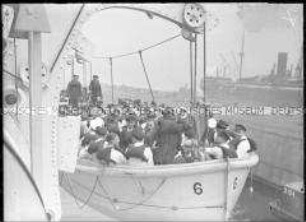 Rettungsübung, Besatzung mit Schwimmwesten in einem frei hängenden Beiboot des Hochseepassagierdampfers "Bremen", im Hintergrund der Hochseepassagierdampfer "Europa"