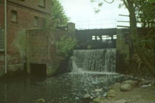 Mühlenstraße 10: Wassermühle: Gerinne, Brücke und Mühlenwehr an Glinder Au: links Mühlengebäude