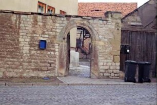 unter Denkmalschutz stehendes rundbogiges Portal in einer Hofmauer