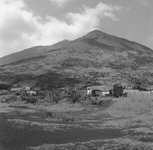 Stromboli, Blick über den Ort mit Ruinen von Gebäuden auf den Vulkan