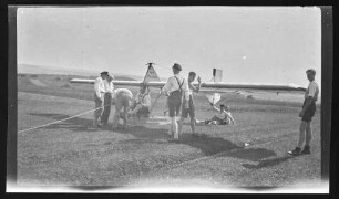 Männer beim Ausrichten des Segelflugzeuges "Stadt Wertheim" mit Pilot und Zugseilen am Flugzeug