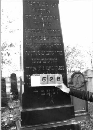 Grabstein 52 (Index: 100116172) Material: Granit, poliert Zustand: gut Maße HxBxT: 255x66x40 cm Beschreibung: dreifach aufgesockelte, obeliskenartige Stele, Schriftfelder auf Stele und mittlerem Sockel: Grabstein 52B (Nachholaufnahme)