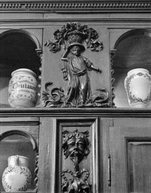 Regalwand aus der ehemaligen Charité-Apotheke in Lyon — Figur mit Blütenkorb auf dem Haupt