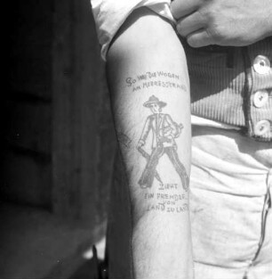 Tätowierung (Wandernder Zimmermann und Schriftzug) auf dem Arm eines Hamburger Zimmermannes