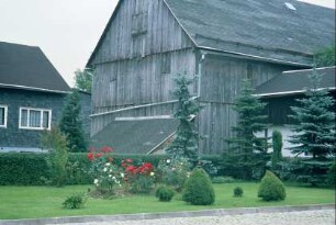 alte Scheune aus Holz, Grünanlage mit Koniferen
