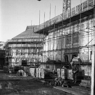 Amtsgericht: Königstraße: in Bau: Außenaufnahme: Rohbau mit Gerüsten, Plastikplanen: Dach mit Lattung: vorne Arbeiter mit Hammer und Klinker: mehrere Palettengebinde mit Klinkern, Holzbalken, Pfützen: im Hintergrund oben Teil von Baukran: Blick von Straße Woldenhorn aus