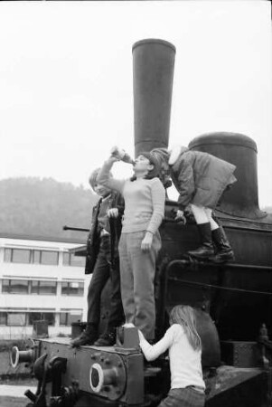 Stegen: Alte Lokomotive im Hof mit Kindern, von unten