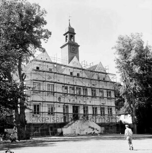 Kloster Nütschau: Herrenhaus: Restaurierung der Nordfront: davor Gerüst: vorn rechts Mann: hinten rechts und links Bäume