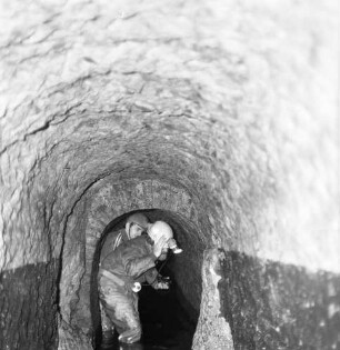 Plauen. Historische Plauener Schlosswasserleitung. Gewölbegang, zum Teil gemauert. Ansicht mit zwei Bergarbeitern