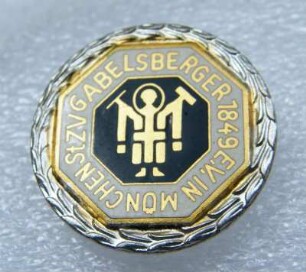 Verdienstabzeichen Stenographen-Zentralverein Gabelsberger München, mit silbernem Lorbeerkranz (mit Broschennadel) : Sammlung Beinhorn. Verdienstabzeichen Stenographen-Zentralverein Gabelsberger München, mit silbernem Lorbeerkranz (mit Broschennadel; rückseitig: Deschler München 9). Email, Metall; Durchmesser 23,5 mm (vor 1945; Deschler & Sohn, München). Dresden: SLUB R c 0290