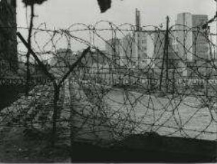 Blick durch Stacheldraht der Berliner Mauer in Berlin