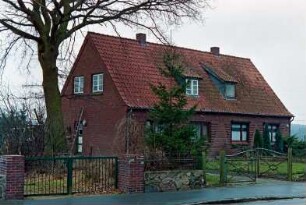 Hamburger Straße 13-15: traufständiges Doppelwohnhaus aus Backstein: Straßenfront: Giebelseite Nr. 13 mit Eingangstür, davor Leiter: Vorgarten, Baum: vorne Gartenzaun, Gartenpforten