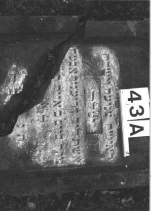 Grabstein 43 (Index: 100105904) Material: Sandstein Zustand: Stein liegend, quer gebrochen mit Textverlust Maße HxBxT: 133x60x17 cm Beschreibung: rechteckige Stele, Sockel, Schriftfeld eingetieft mit Spitzbogenabschluß Symbolik: Maßwerk: Grabstein 43A (2)
