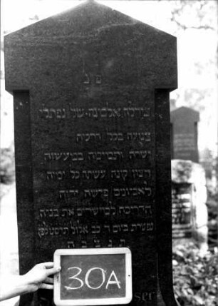 Grabstein 30 (Index: 100110040) Material: Granit Zustand: gut Maße HxBxT: 194x70x26 cm Beschreibung: Stele, getreppter Sockel, giebelartiger Abschluß Symbolik: eckige Voluten Steinmetz: Ostberg: Grabstein 30A