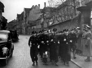 Eine Hamburger Schulklasse marschiert uniformiert zum Bahnhof. Im Rahmen der Kinderlandverschickung werden sie von der Bomben bedrohten Hansestadt nach Hof/Bayern reisen.