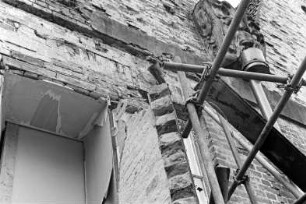 Gut Jersbek: Herrenhaus: Nordgiebel: Sanierung: Detailaufnahme: Fensteröffnung, Schäden an Mauerwerk, unter Wasserspeier Maskaron Abflussrohr, davor Gerüst