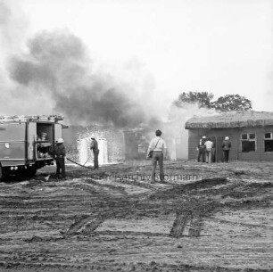 Stemwarde: Kreisfeuerwehrverbandstag: Löschübung: hinten Feuerwehrmänner beim Löschen von Tankstelle und Wohnhaus: links Löschwagen: davor Feuerwehrmänner beim Verlegen der Wasserschläuche