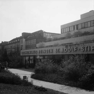 Krankenhäuser: Krankenhaus Reinbek St. Adolf-Stift: Hamburger Straße: Mittelbau mit Namenszug: davor Grünanlage mit Büschen und Bäumen: links Mann: dahinter Altbau und Erweiterungsbau