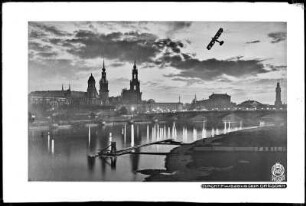 Dresden bei Nacht mit Flugzeug über der Stadt, Blick vom Neustädter Elbufer auf Augustusbrücke, Residenzschloss und Katholische Hofkirche