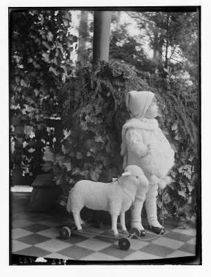 Die Tochter der Fotografin im Wintermantel und mit Lamm als Wagentier