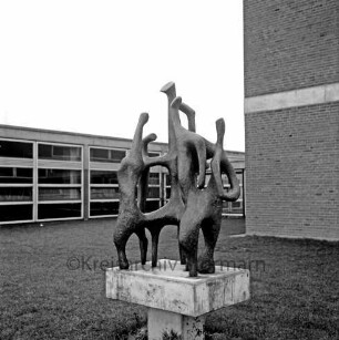 Emil-von-Behring-Gymnasium: Sieker Landstraße: Kunst am Bau: vorn Grünanlage mit Bronzeplastik "Das Gespräch" des Bildhauers Ferdinand Mathiszig: dahinter Schulgebäude