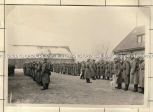 Angehörige der Ordnungspolizei mit Marschgepäck in Aufstellung auf einem Innenhof