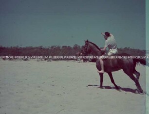 Soldat ohne Uniform reitet am Strand eines Flusses