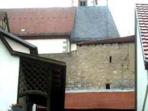 Ansicht von Süden aus dem Ort mit Kirchhofmauer als Außenwand eines Gaden im Detail - Wehrgang mit Schießscharten aus Gaden zu bedienen