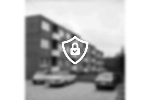 Wolkenweher Weg: Wohnblock der Gemeinnützigen Wohnstättengenossenschaft eG Bad Oldesloe: davor Grünanlage: vorn Parkplatz mit Pkws