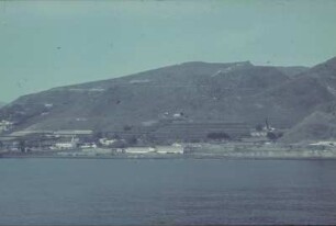Reisefotos. Blick von einem Passagierschiff zur gebirgigen Küste (vielleicht im Mittelmeerraum)