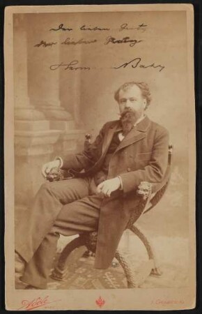 Hermann Bahr sitzt in einem Sessel, im Hintergrund Säulen, mit Widmung