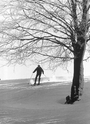 Der verschneite Harz im Winter. Ein Skifahrer fährt einen Hang hinunter. Aufgenommen 1963